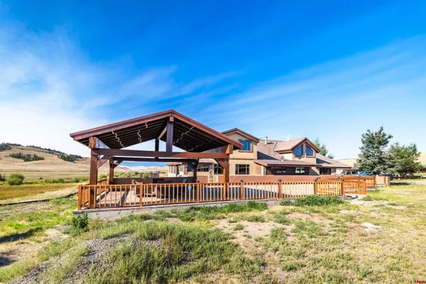 a front view of a house with a big yard and large trees