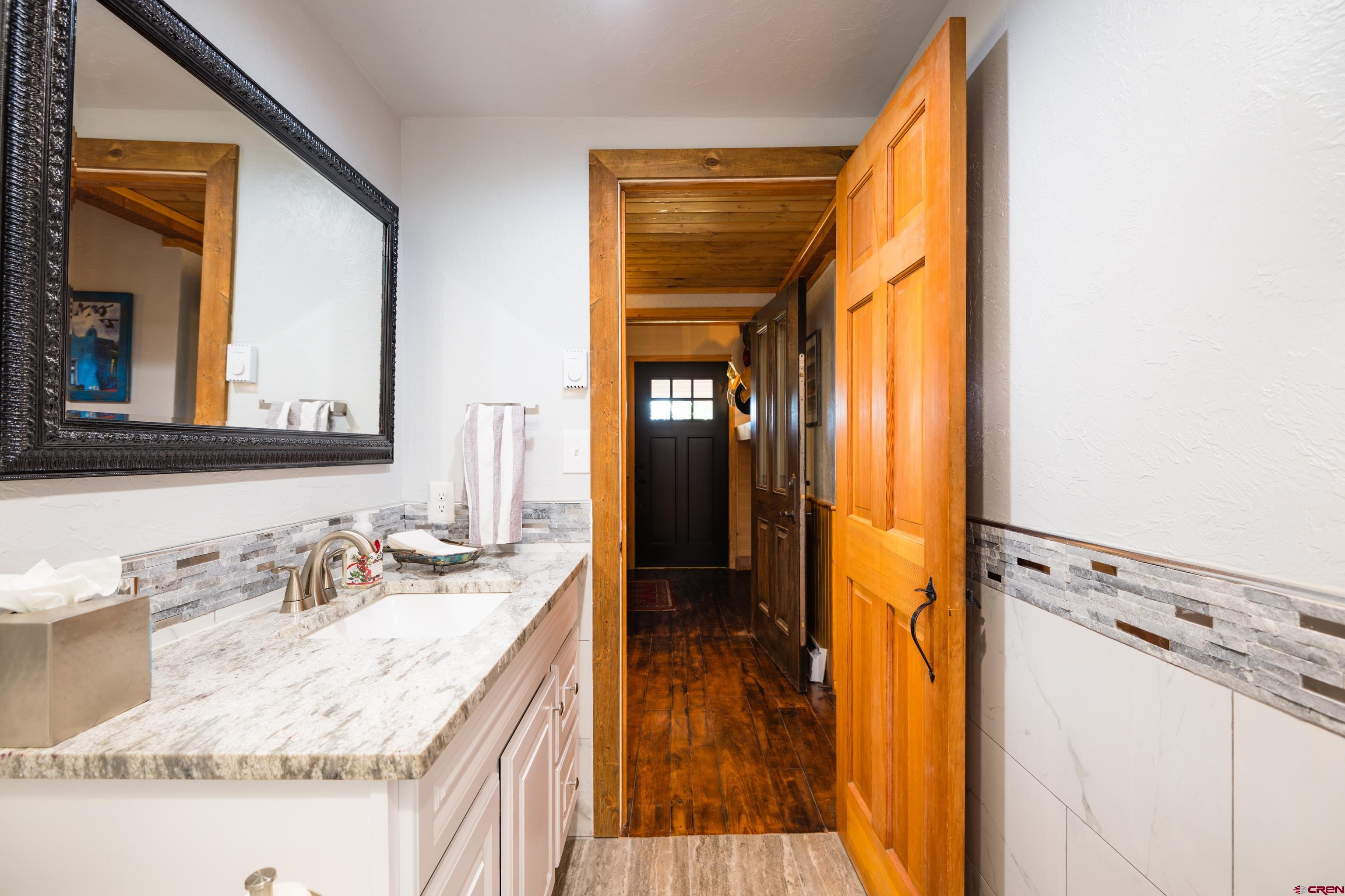 28890 County Road Saguache, CO 81149 - Photo 13 of 45 a en suite bathroom with a granite countertop sink and a mirror
