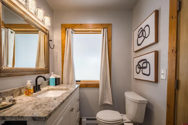 a bathroom with a granite countertop shower a sink and a mirror