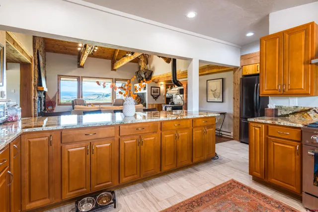 a kitchen with stainless steel appliances granite countertop a sink and wooden cabinets