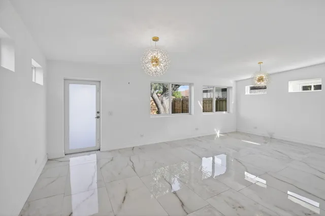 a view of an empty room with chandelier