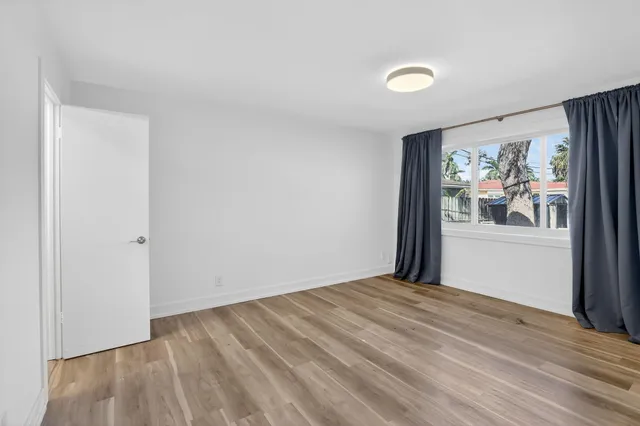 a view of a livingroom with wooden floor and window