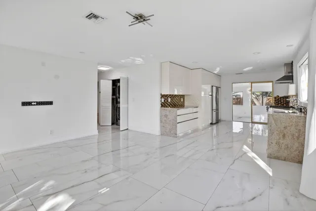 a view of a kitchen with refrigerator and white cabinets