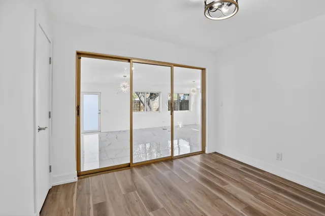 a view of a room with wooden floor and mirror