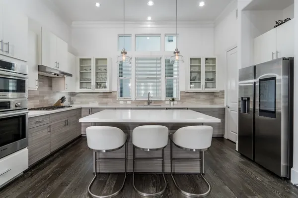 a kitchen with a table chairs refrigerator and cabinets