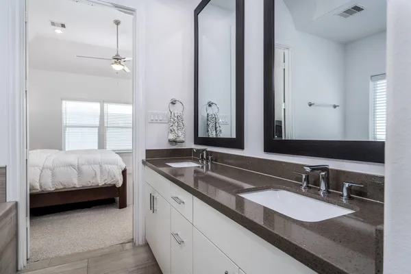a en suite bathroom with a double vanity sink and a mirror