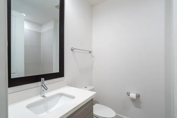 a bathroom with a sink a toilet and mirror