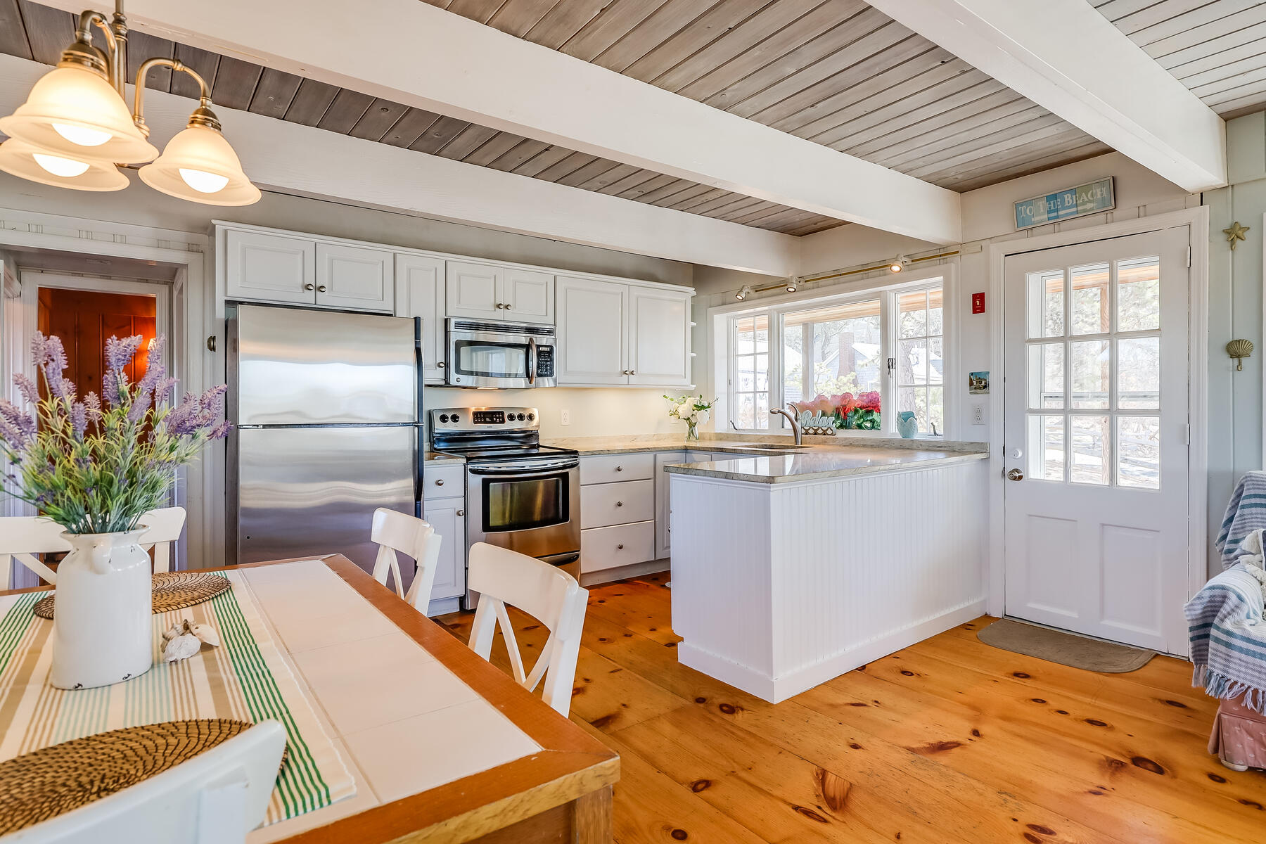 155 Nauhaught Bluff Road Wellfleet, MA 02667 - Photo 9 of 53 a kitchen with kitchen island a counter top space a sink stainless steel appliances and cabinets