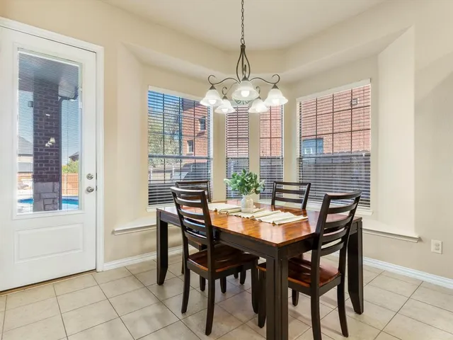 a dining room with furniture a chandelier and window