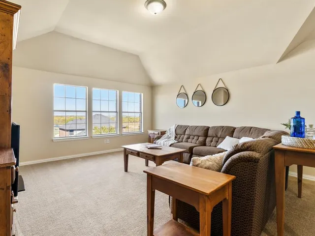 a living room with furniture and a view of kitchen