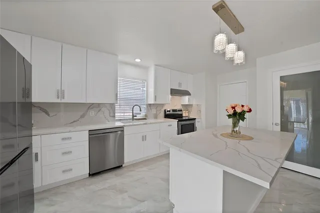 a kitchen with granite countertop white cabinets and white appliances