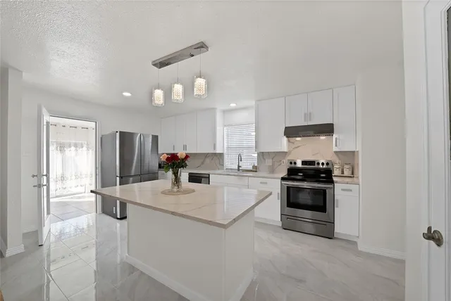 a kitchen with stainless steel appliances granite countertop a sink stove oven and refrigerator