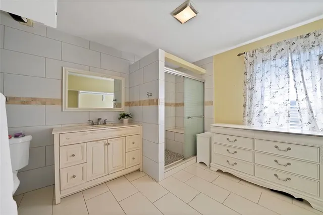 a white bed sitting in a room next to a window