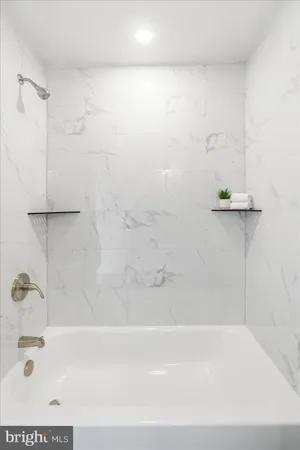 a bathroom with a toilet a sink a mirror and bathtub
