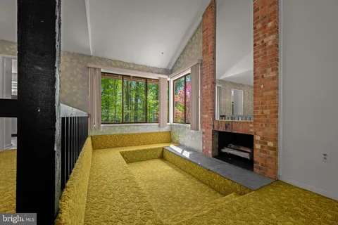 a view of living room with furniture and a fireplace