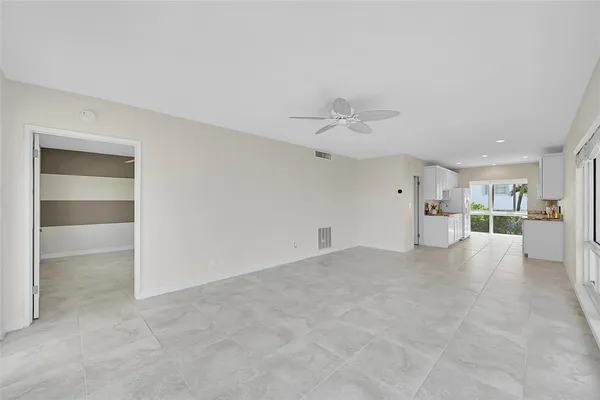 an empty room with windows and fan