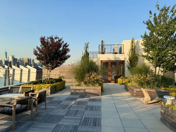 a view of a patio with couches table and chairs and potted plants