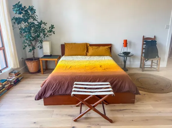 a bedroom with a bed and a potted plant