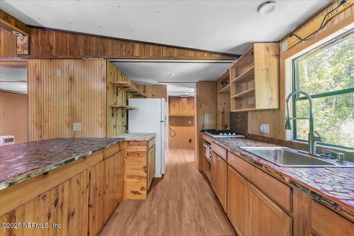 506 Cedar Creek Road, Unit 1 Palatka, FL 32177 - Photo 11 of 49 a kitchen with stainless steel appliances granite countertop a sink a stove and a wooden floors