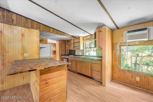 a kitchen with stainless steel appliances granite countertop hardwood floor sink stove and wooden cabinets