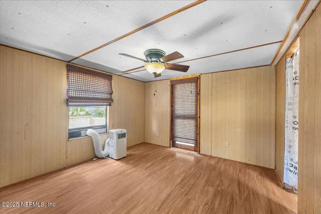 a very nice looking room with a large window and chandelier fan