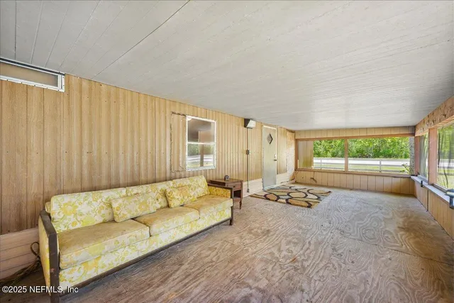 a living room with furniture and a floor to ceiling window