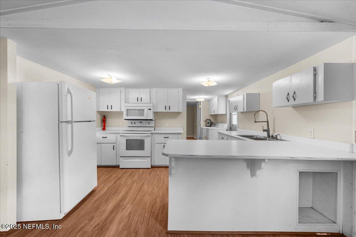 506 Cedar Creek Road, Unit 1 Palatka, FL 32177 - Photo 30 of 49 a kitchen with white cabinets and stainless steel appliances