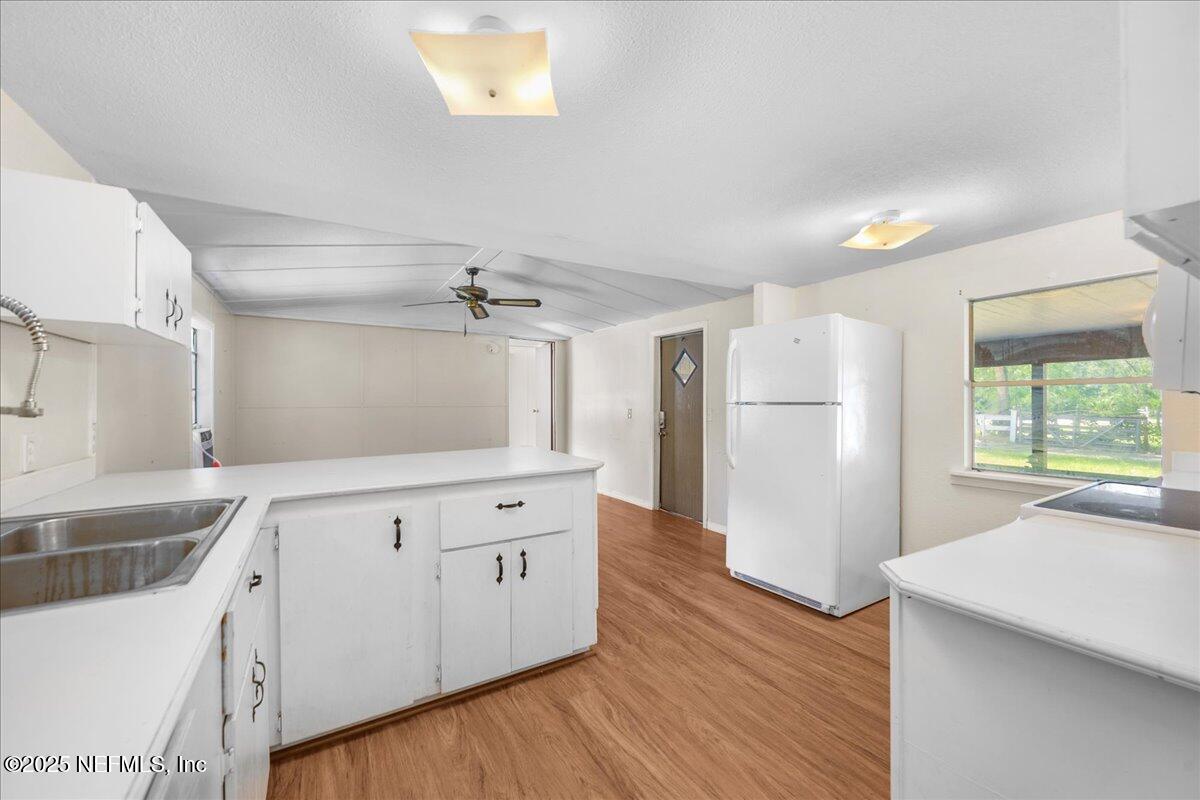 506 Cedar Creek Road, Unit 1 Palatka, FL 32177 - Photo 31 of 49 a kitchen with a refrigerator a sink and wooden floor