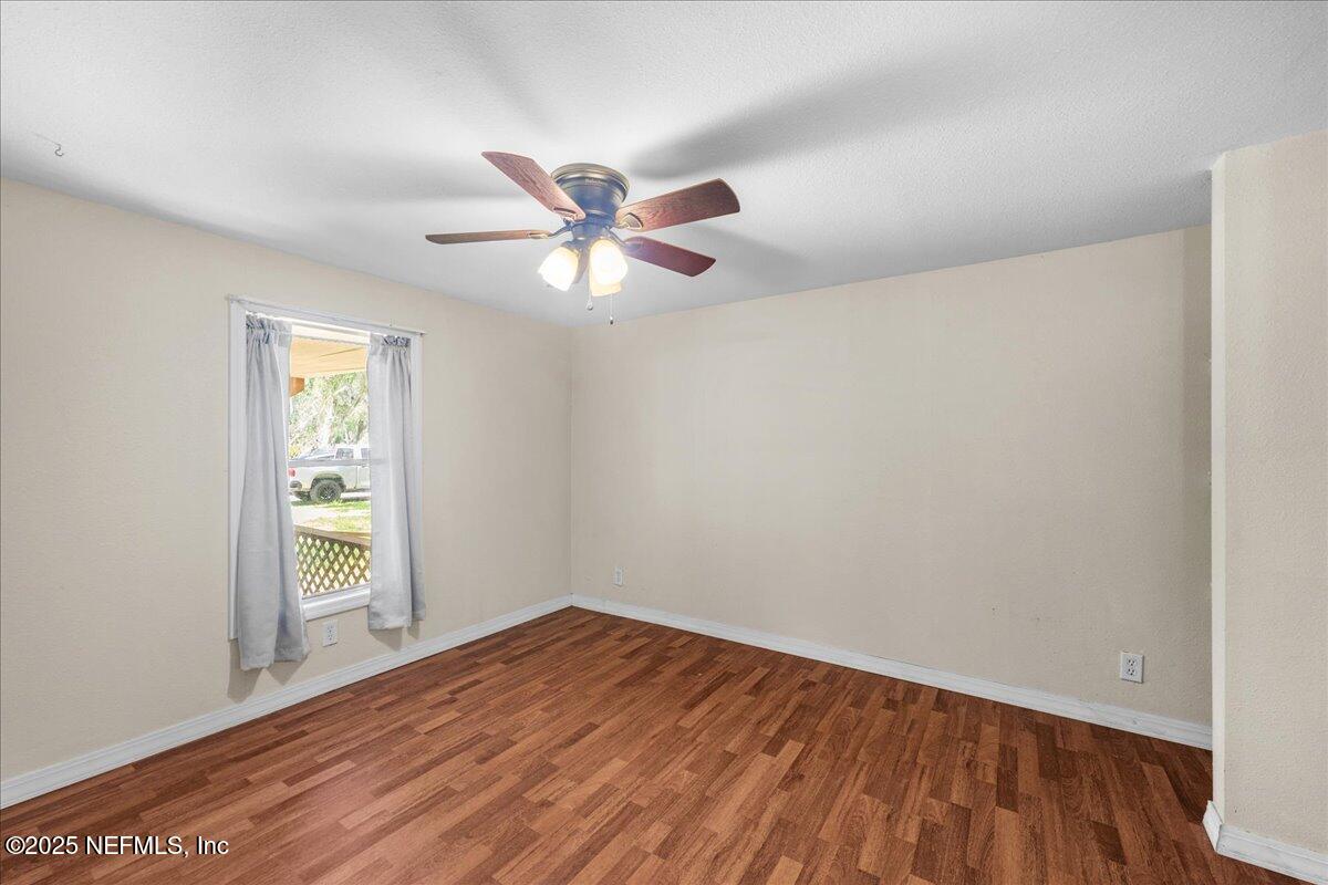 506 Cedar Creek Road, Unit 1 Palatka, FL 32177 - Photo 34 of 49 an empty room with wooden floor chandelier fan and windows