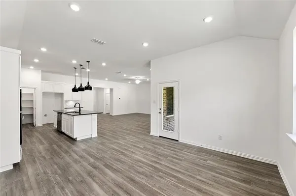 a kitchen with stainless steel appliances kitchen island granite countertop a stove a sink and a refrigerator