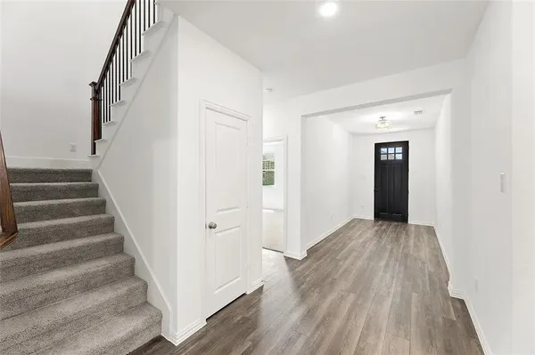 a view of a hallway with wooden floor and entryway