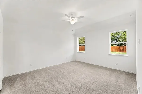 an empty room with a window and a fan