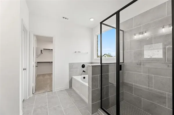 a bathroom with a bathtub and a glass door shower