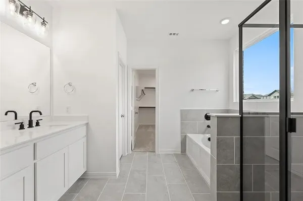 a bathroom with a tub sink and mirror
