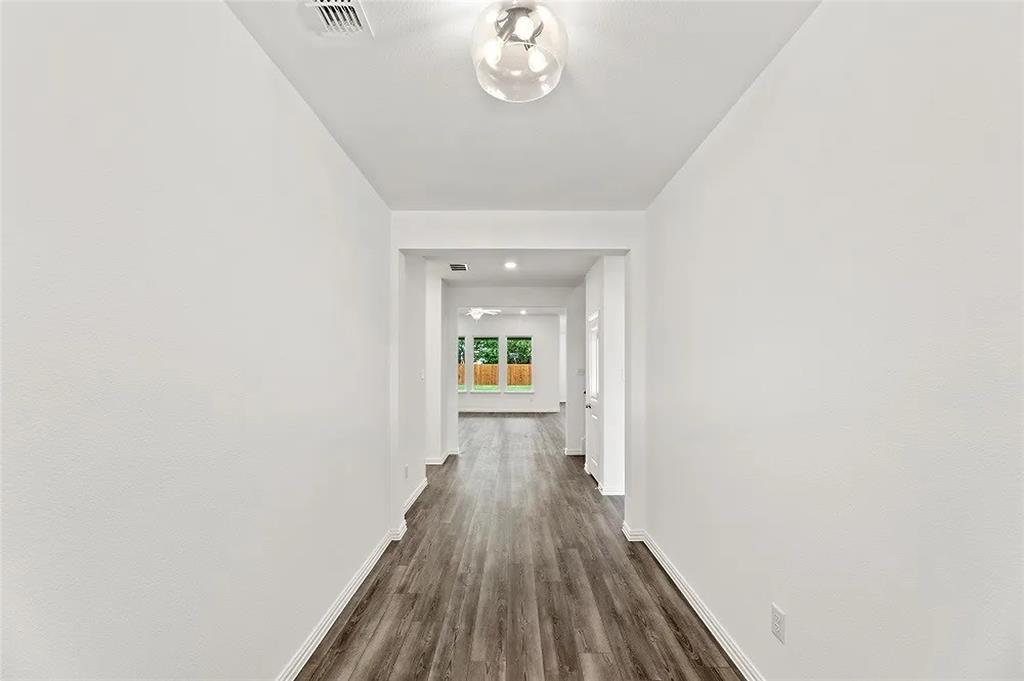 1632 Pavin Lane Fort Worth, TX 76052 - Photo 3 of 37 a view of a hallway view with wooden floor and staircase