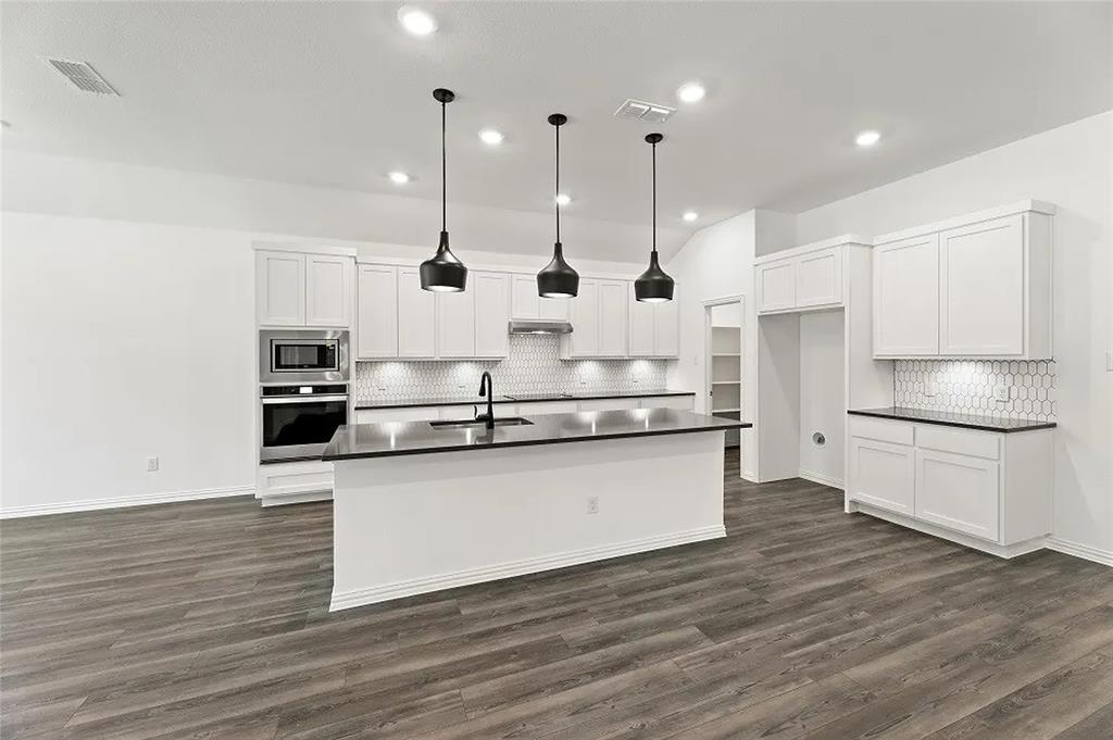 1632 Pavin Lane Fort Worth, TX 76052 - Photo 8 of 37 a kitchen with stainless steel appliances granite countertop a sink a stove and a wooden floors