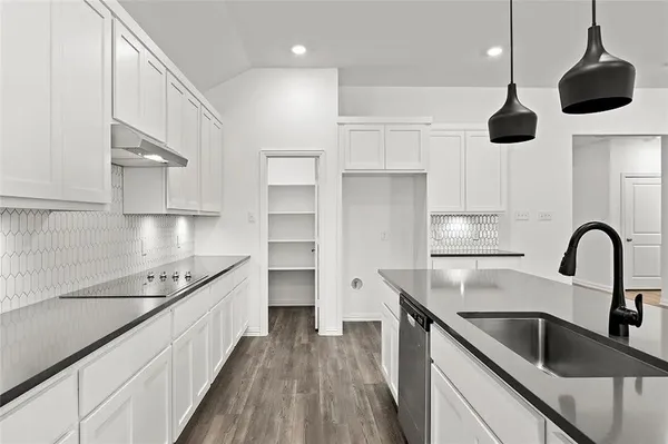a kitchen with kitchen island stainless steel appliances a sink center island and cabinets