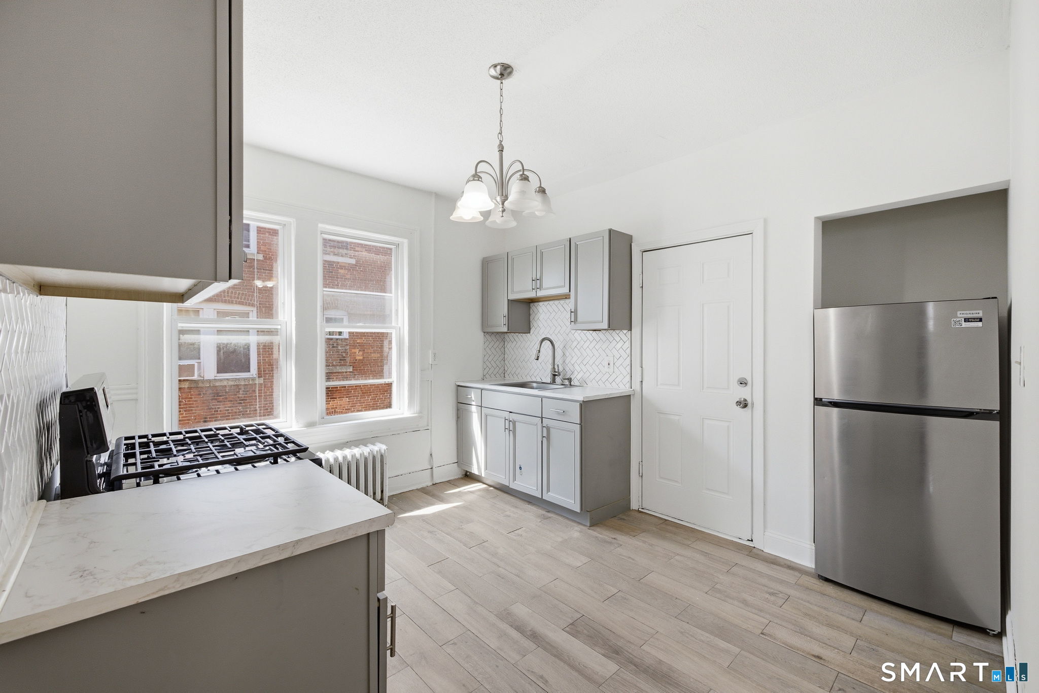 115 Baltimore Street, Unit 2 Hartford, CT 06112 - Photo 6 of 14 a kitchen with a refrigerator and a stove top oven