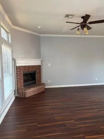 a view of a livingroom with a fireplace a ceiling fan and window
