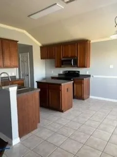 a kitchen with stainless steel appliances granite countertop a stove top oven a sink a counter top space and cabinets