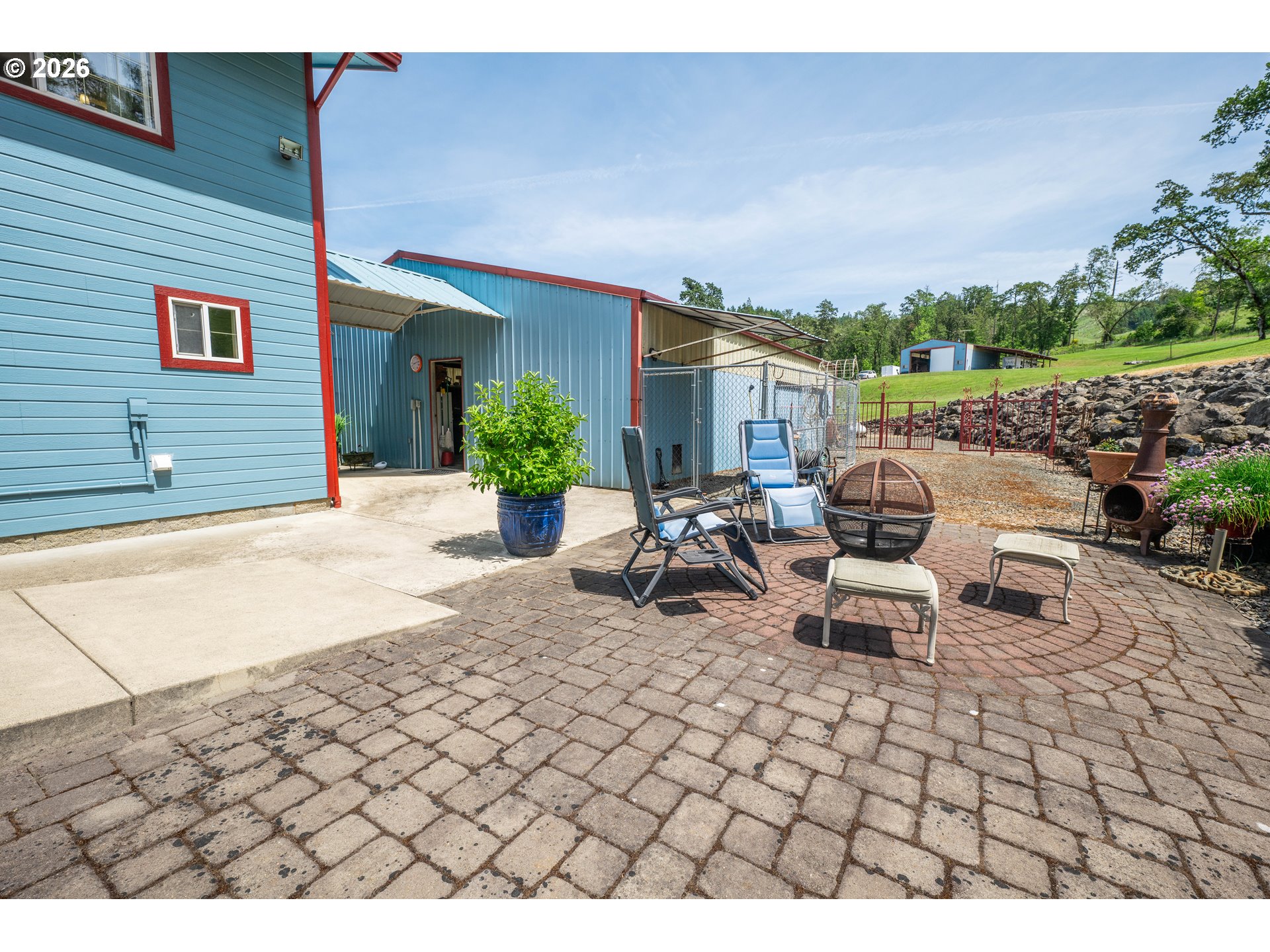 489 Fir Vista Road Sutherlin, OR 97479 - Photo 30 of 47 a view of a patio with dining table and chairs with plants and wooden fence