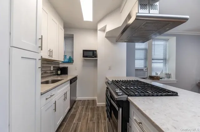 a kitchen with stainless steel appliances granite countertop a stove sink and cabinets