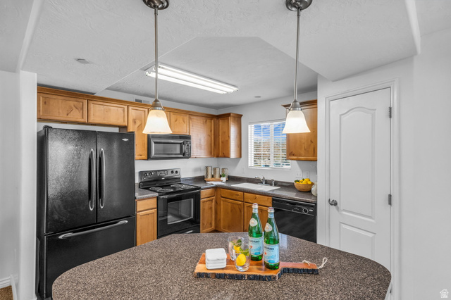 1136 West Spencer Road, Unit Y203 Pleasant Grove, UT 84062 - Photo 9 of 26 Kitchen featuring black appliances, decorative light fixtures, a textured ceiling, and wood finish cabinets