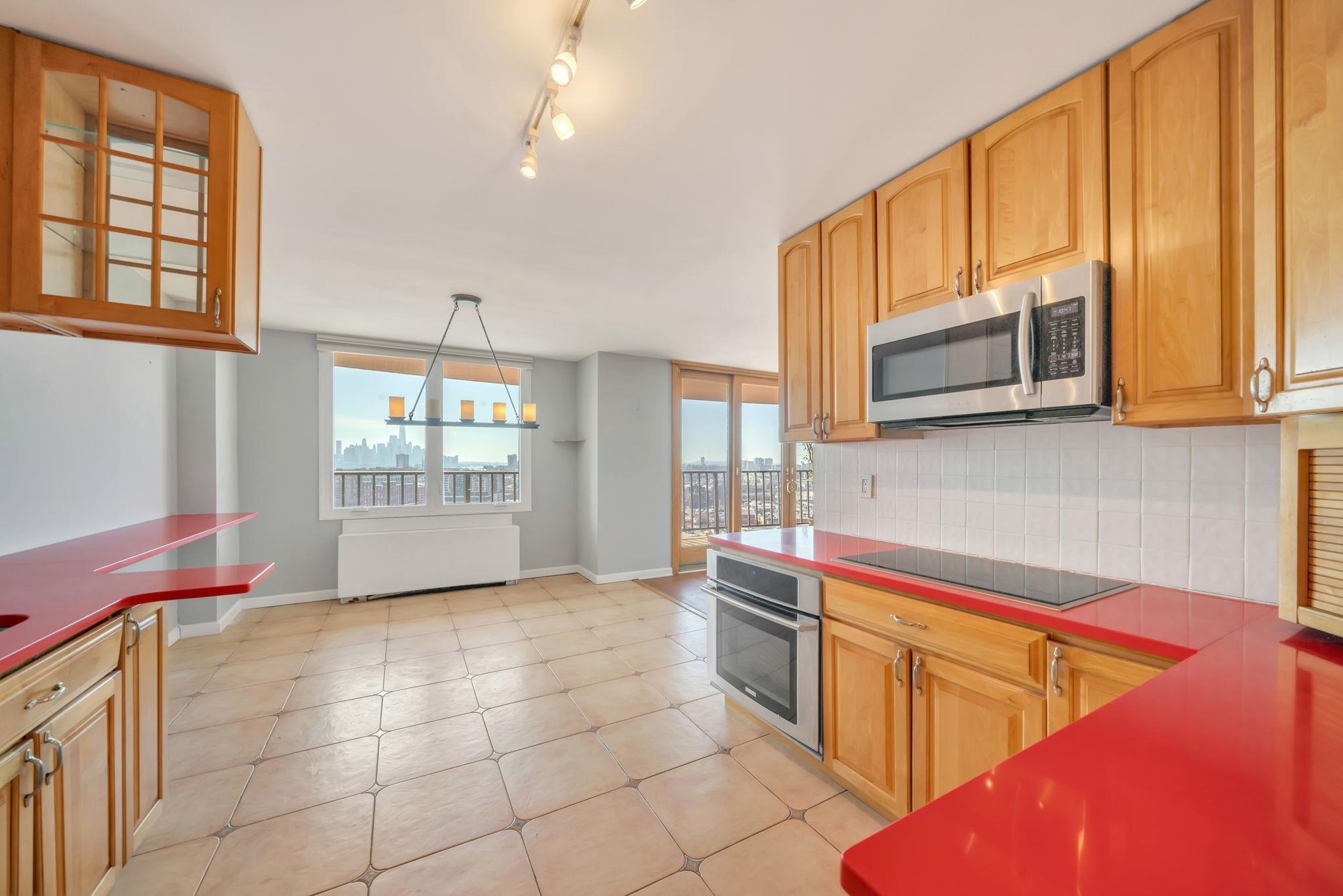 380 Mountain Road, Unit 213 Union City, NJ 07087 - Photo 13 of 36 a kitchen with stainless steel appliances a sink a stove cabinets and a window