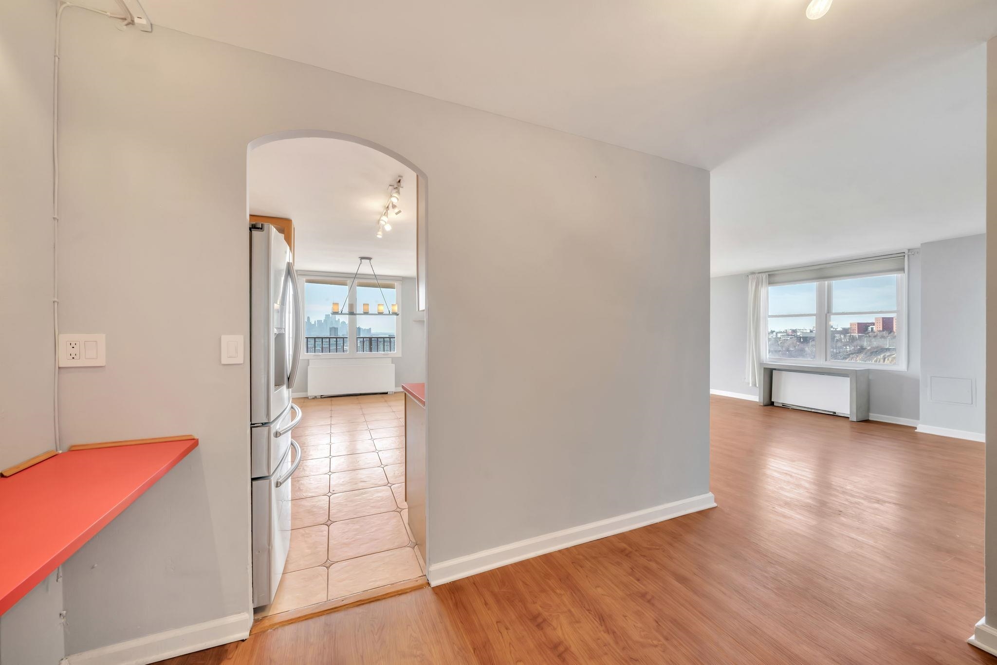 380 Mountain Road, Unit 213 Union City, NJ 07087 - Photo 17 of 36 an empty room with wooden floor kitchen view and windows