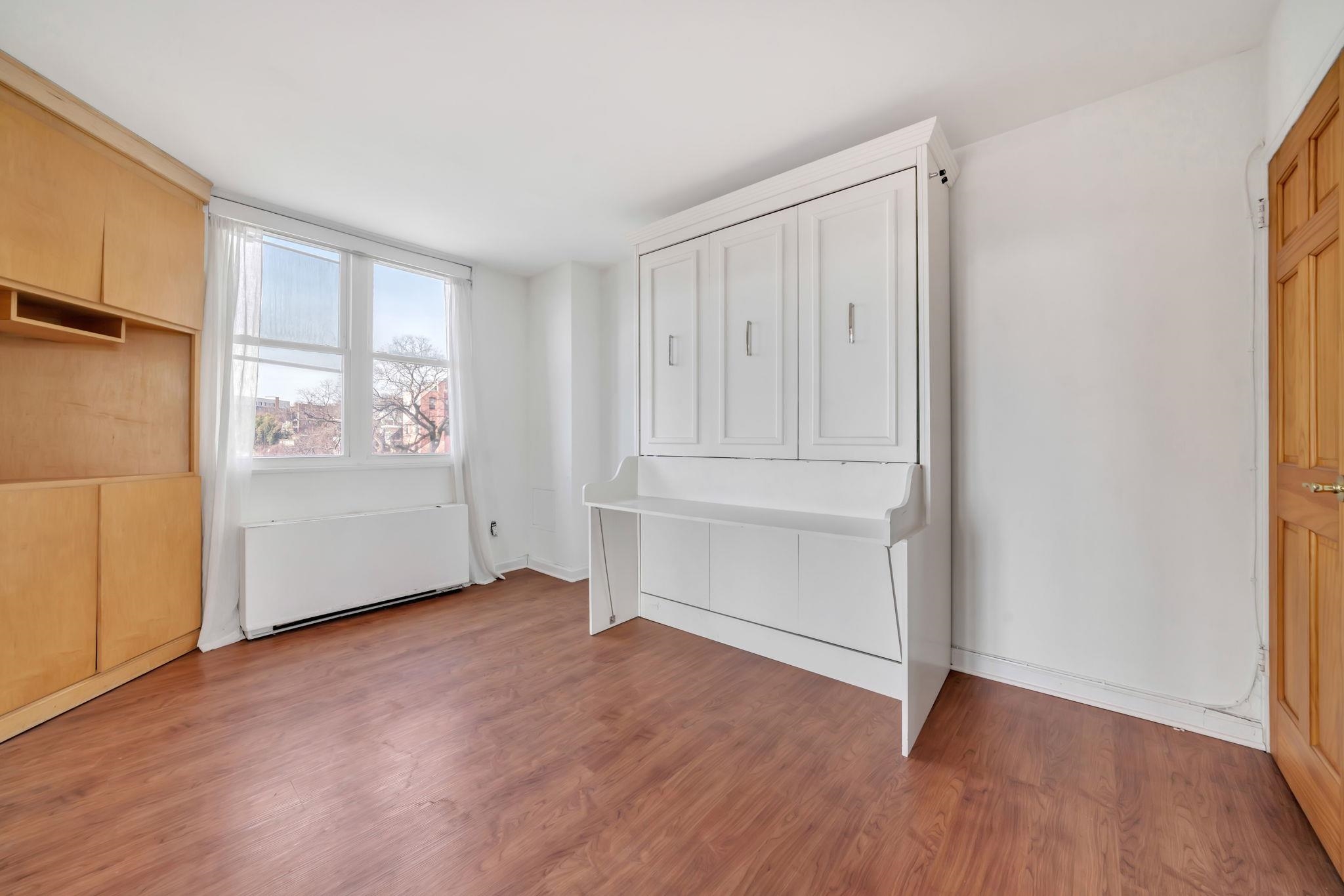 380 Mountain Road, Unit 213 Union City, NJ 07087 - Photo 19 of 36 an empty room with wooden floor cabinet and windows