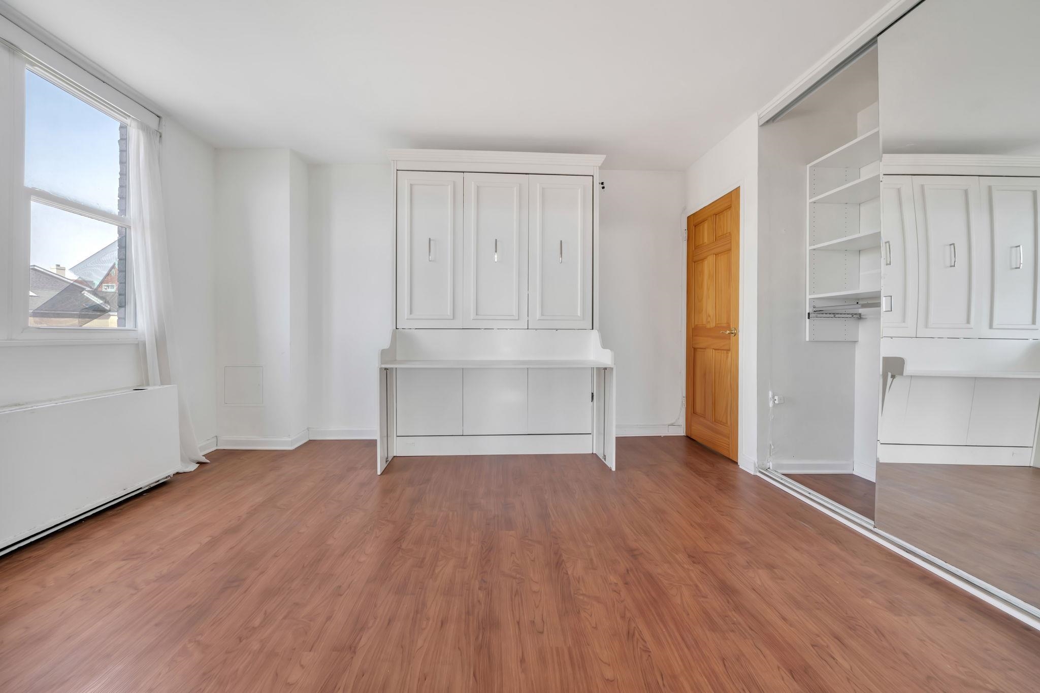 380 Mountain Road, Unit 213 Union City, NJ 07087 - Photo 22 of 36 an empty room with wooden floor and windows