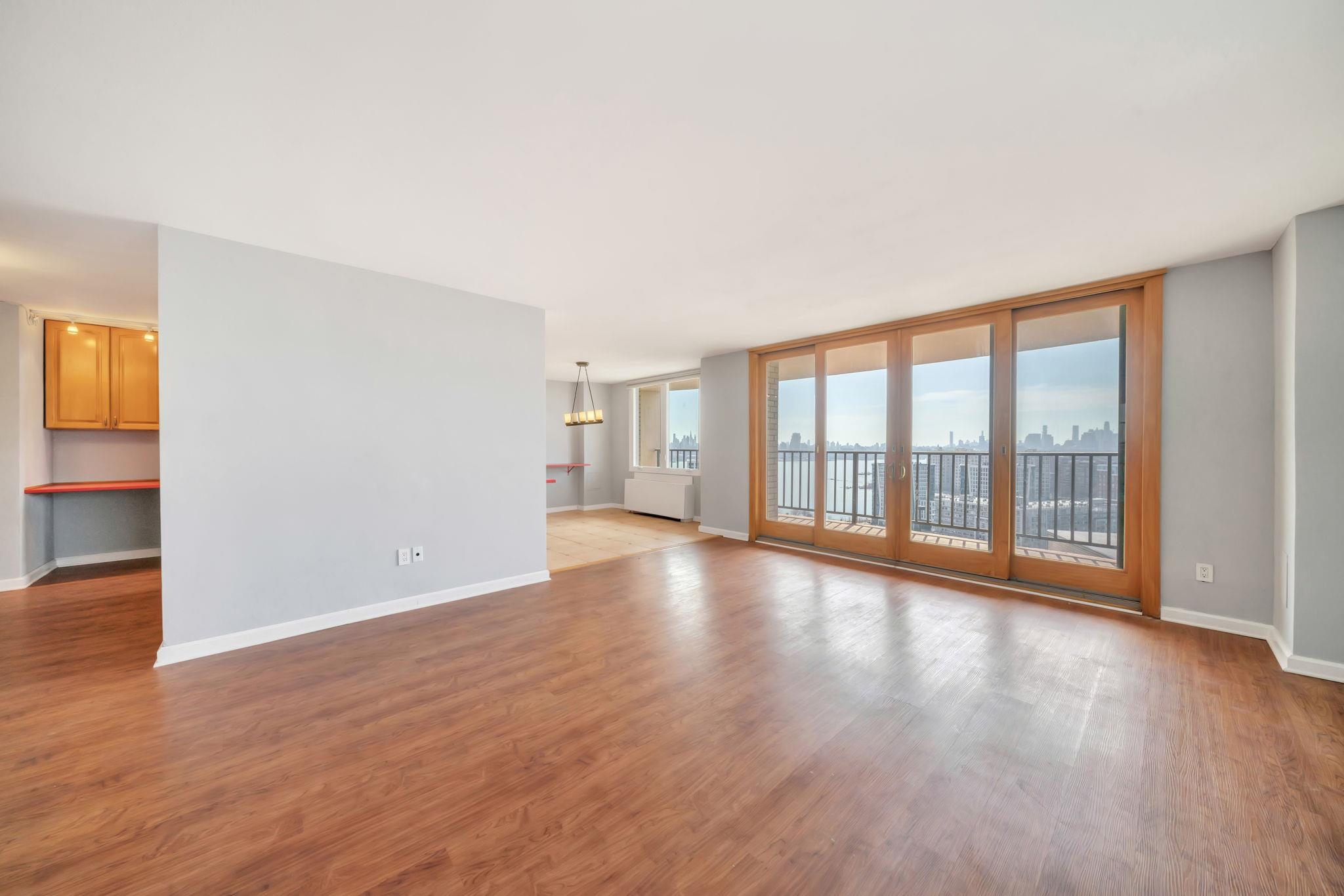 380 Mountain Road, Unit 213 Union City, NJ 07087 - Photo 4 of 36 a view of an empty room with wooden floor and a window
