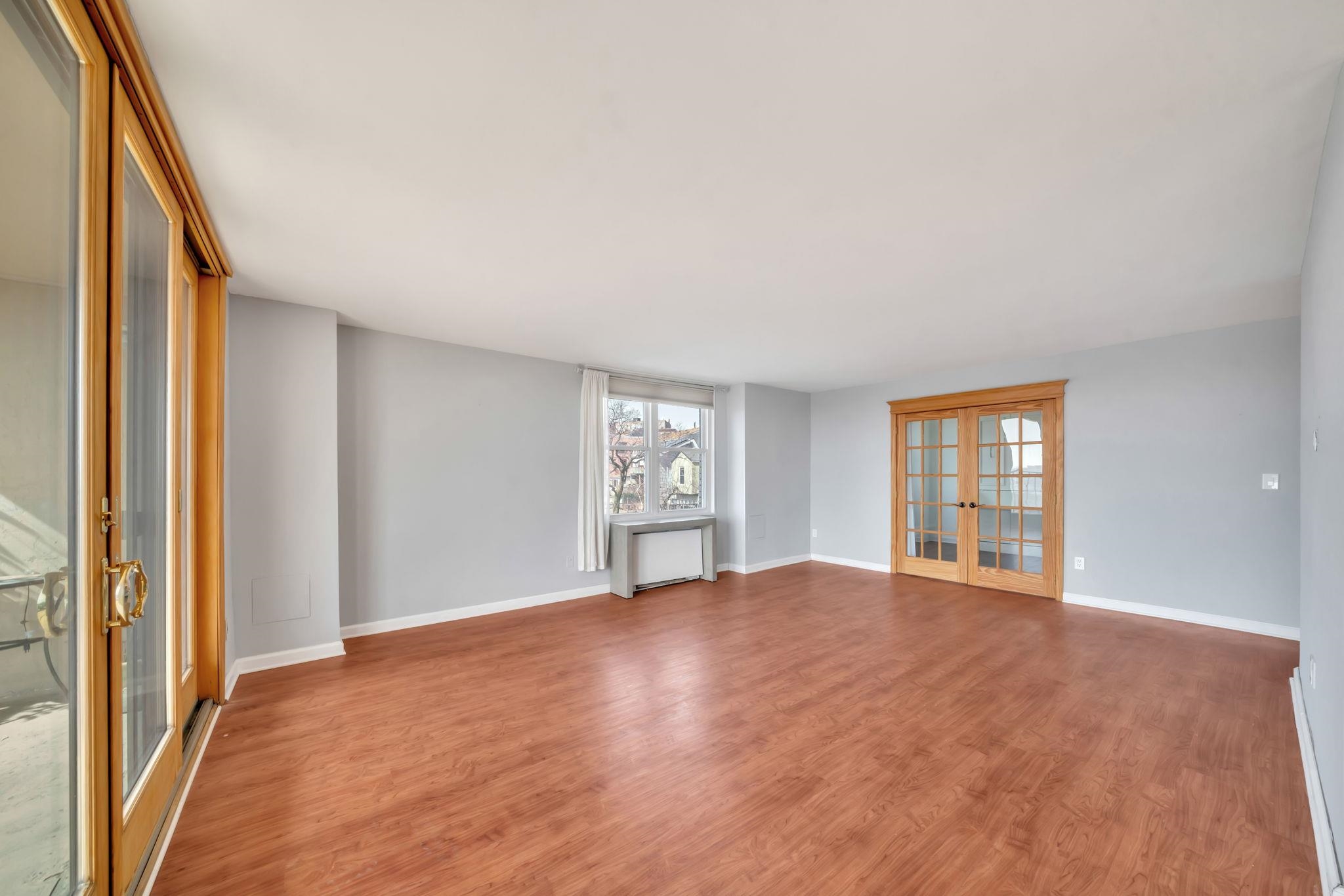 380 Mountain Road, Unit 213 Union City, NJ 07087 - Photo 6 of 36 a view of an empty room with window and wooden floor