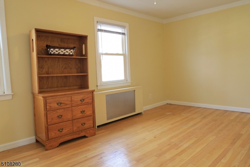 159 Prospect Street, Unit 2 Garfield, NJ 07026 - Photo 4 of 13 an empty room with cabinet and wooden floor